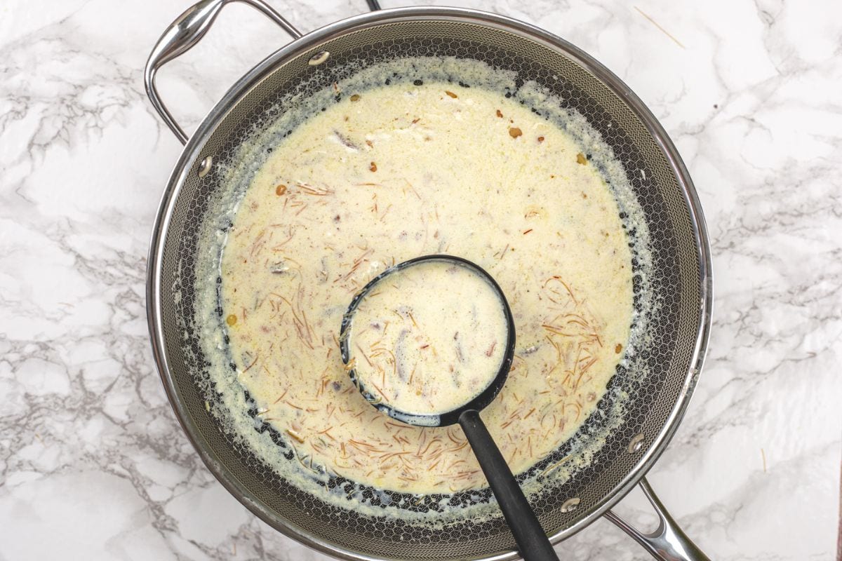 A ladleful of sheer khurma taking from the pan.