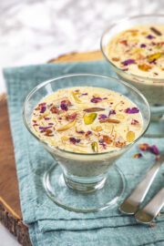 Sheer kurma served in glass bowl with spoons on the side.