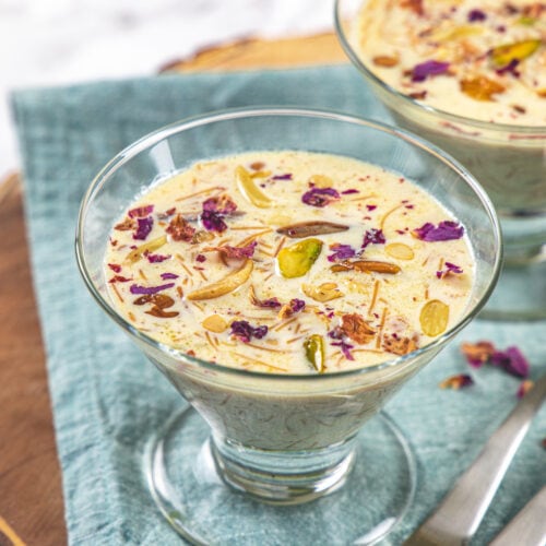 Sheer kurma served in glass bowl with spoons on the side.