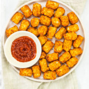 Air fryer tater tots served with ketchup.