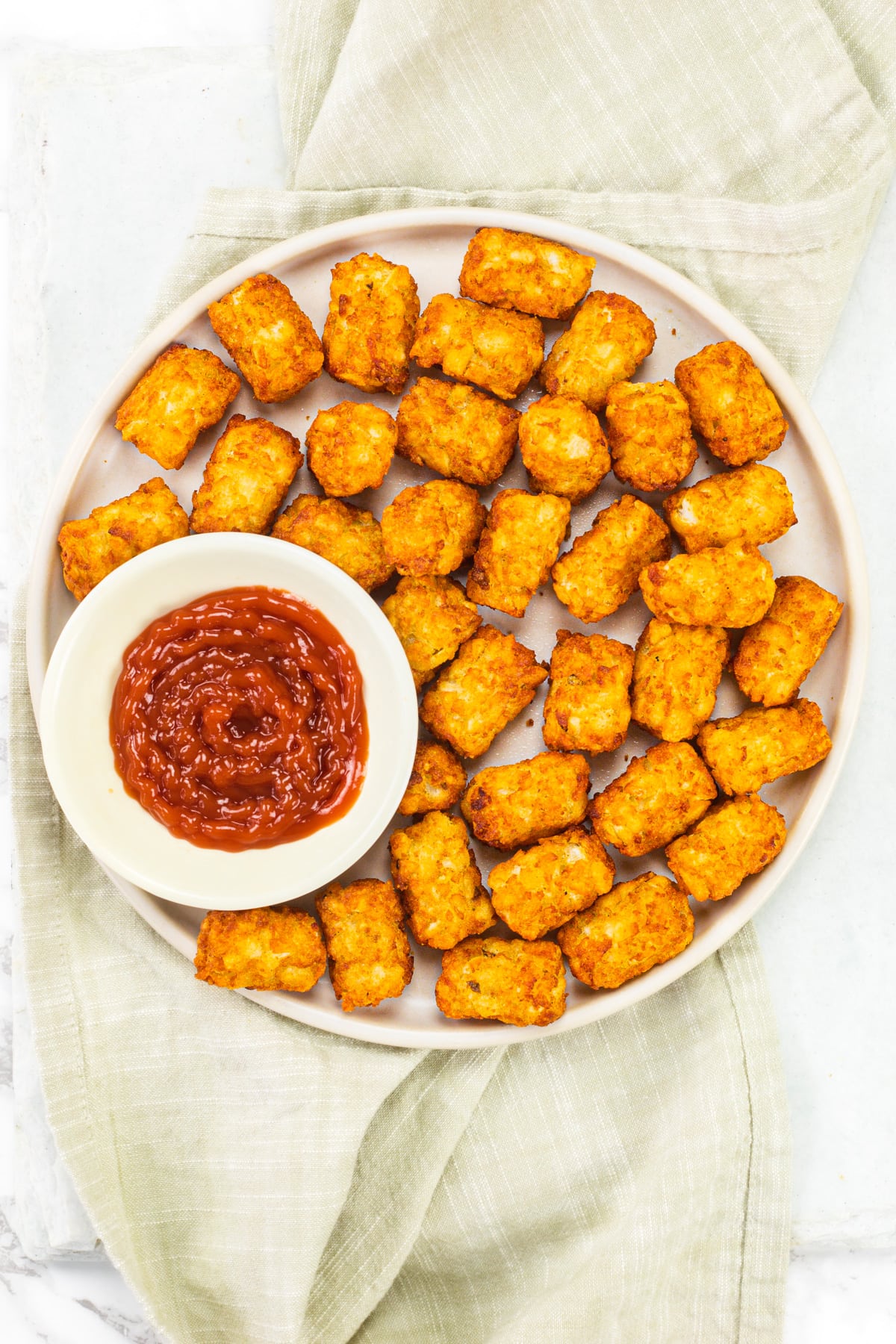 Air fryer tater tots served with ketchup.