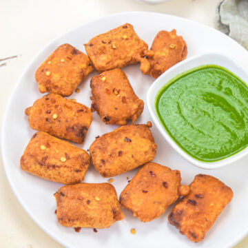 Paneer pakora served with green chutney and ketchup.