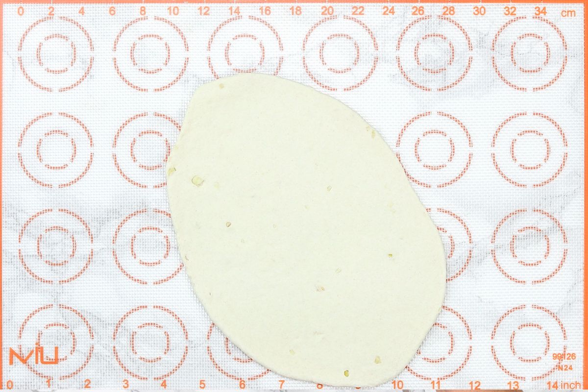 Roll garlic naan on a silicone mat.