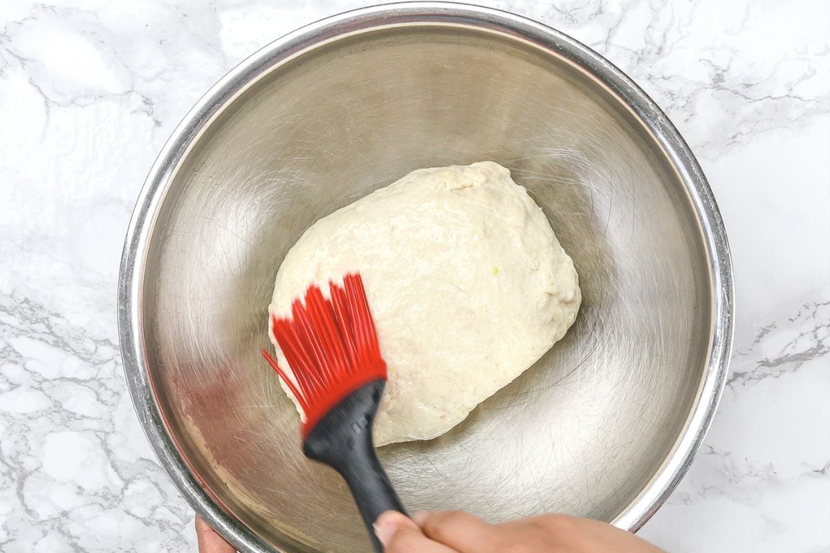 Brushing dough ball with oil.