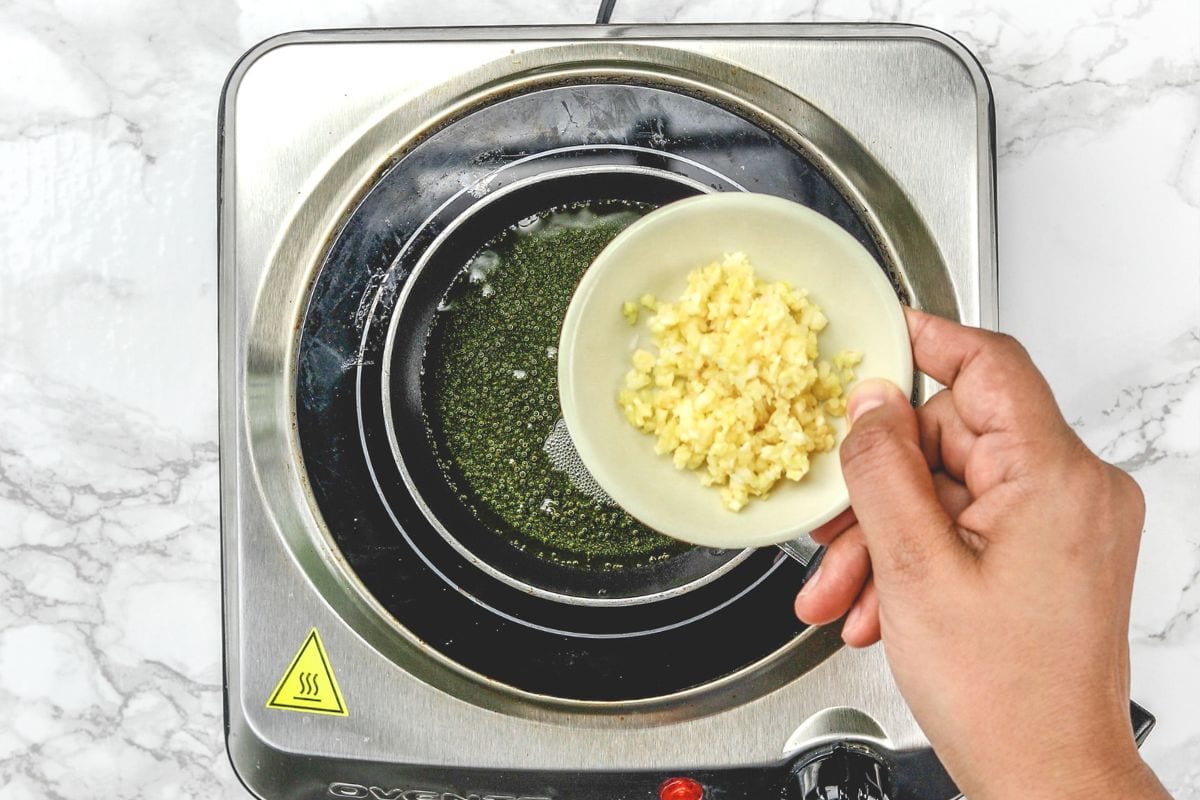 Adding garlic in hot ghee.