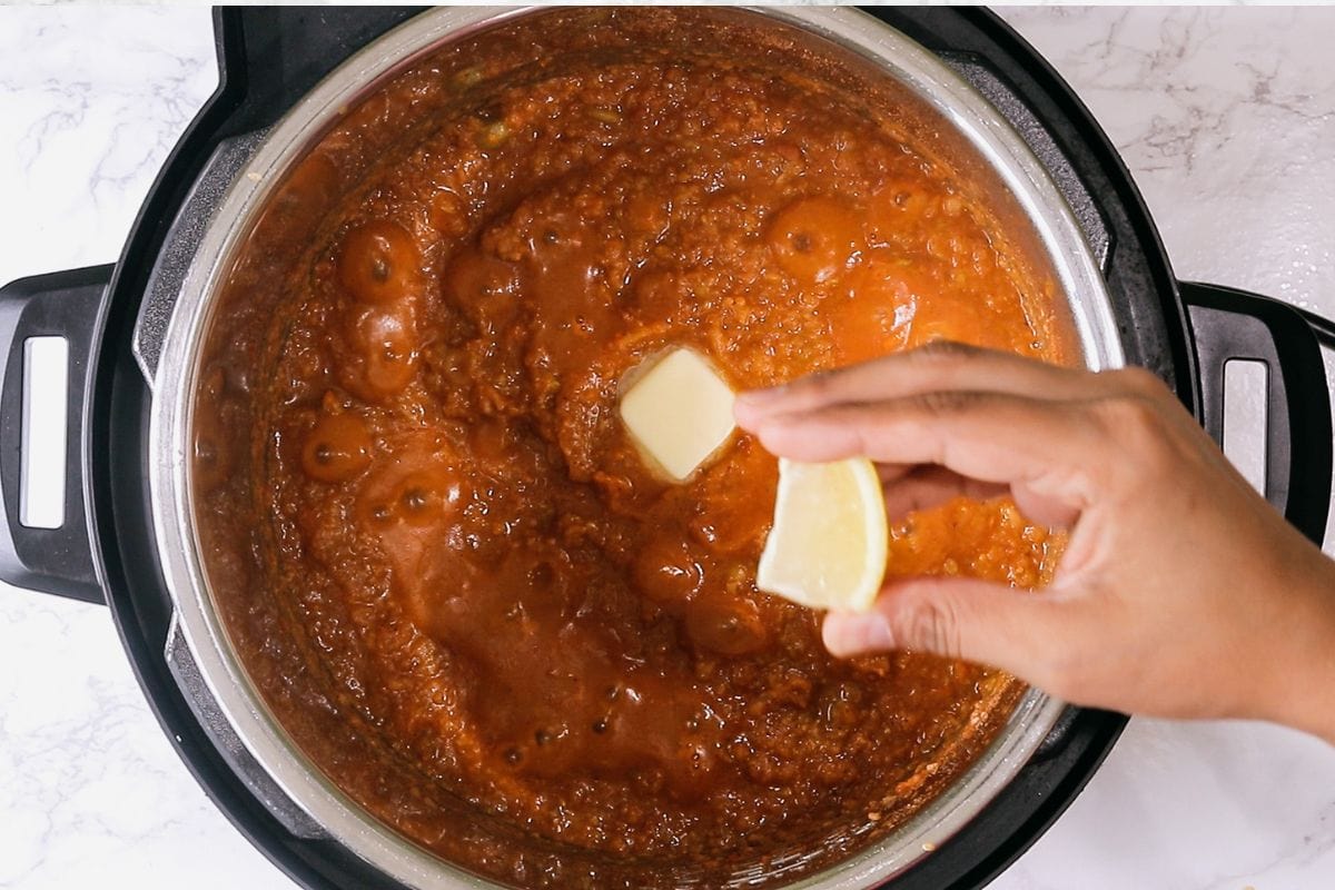 Adding butter and lemon juice to bhaji.