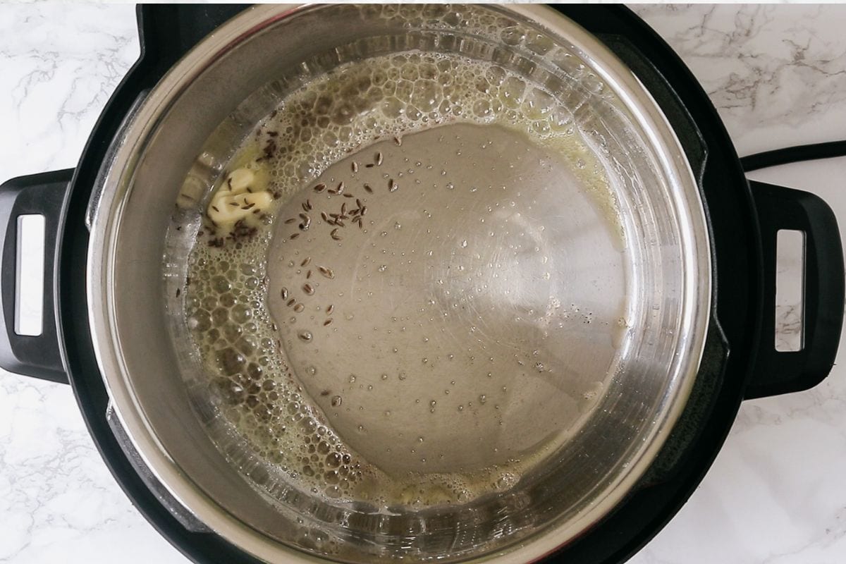 Sauteing cumin seeds in butter.