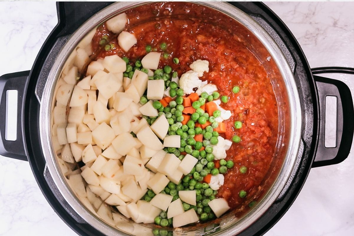 Adding potatoes and veggies.
