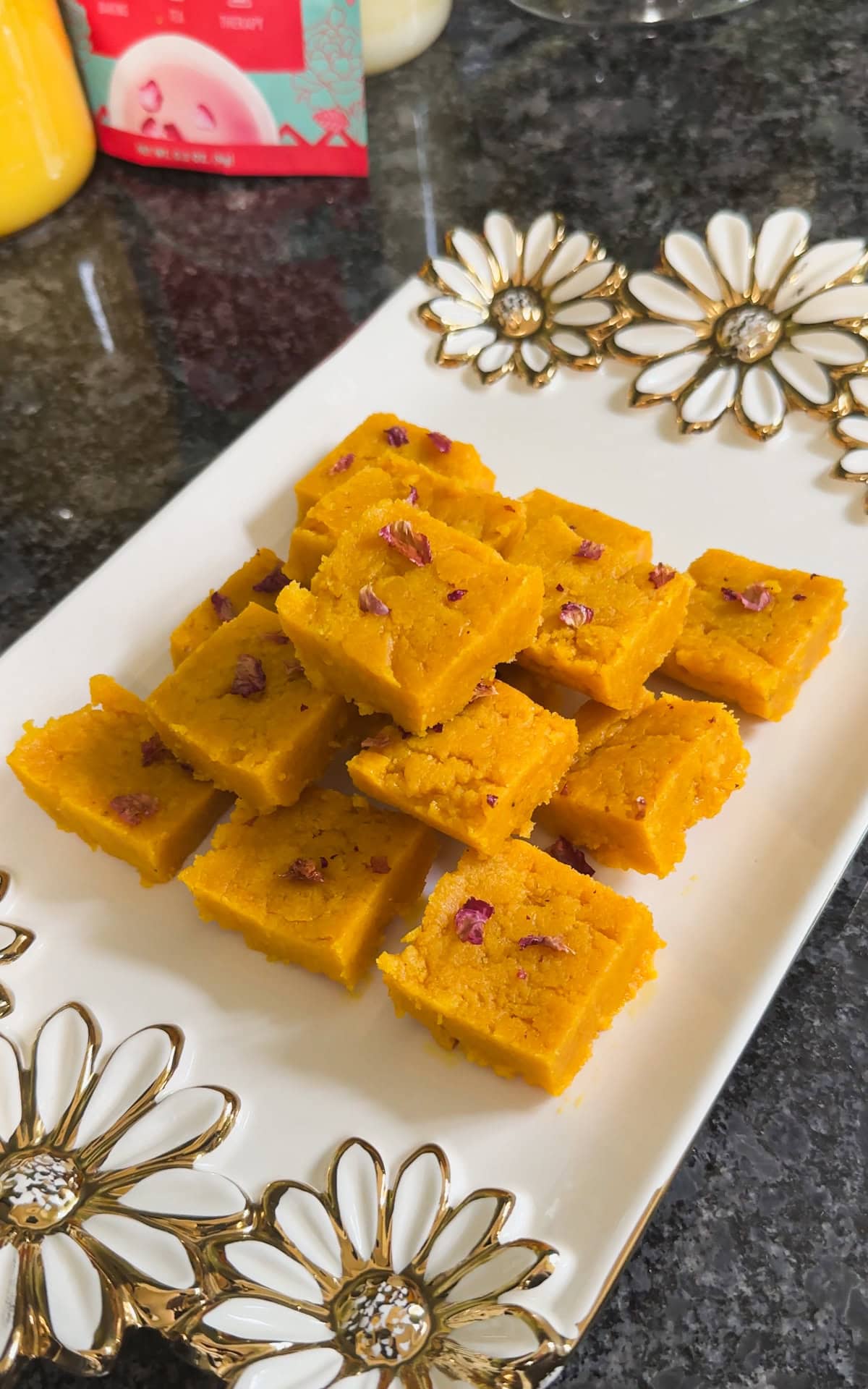A stack of mango burfi in a white gold plate.