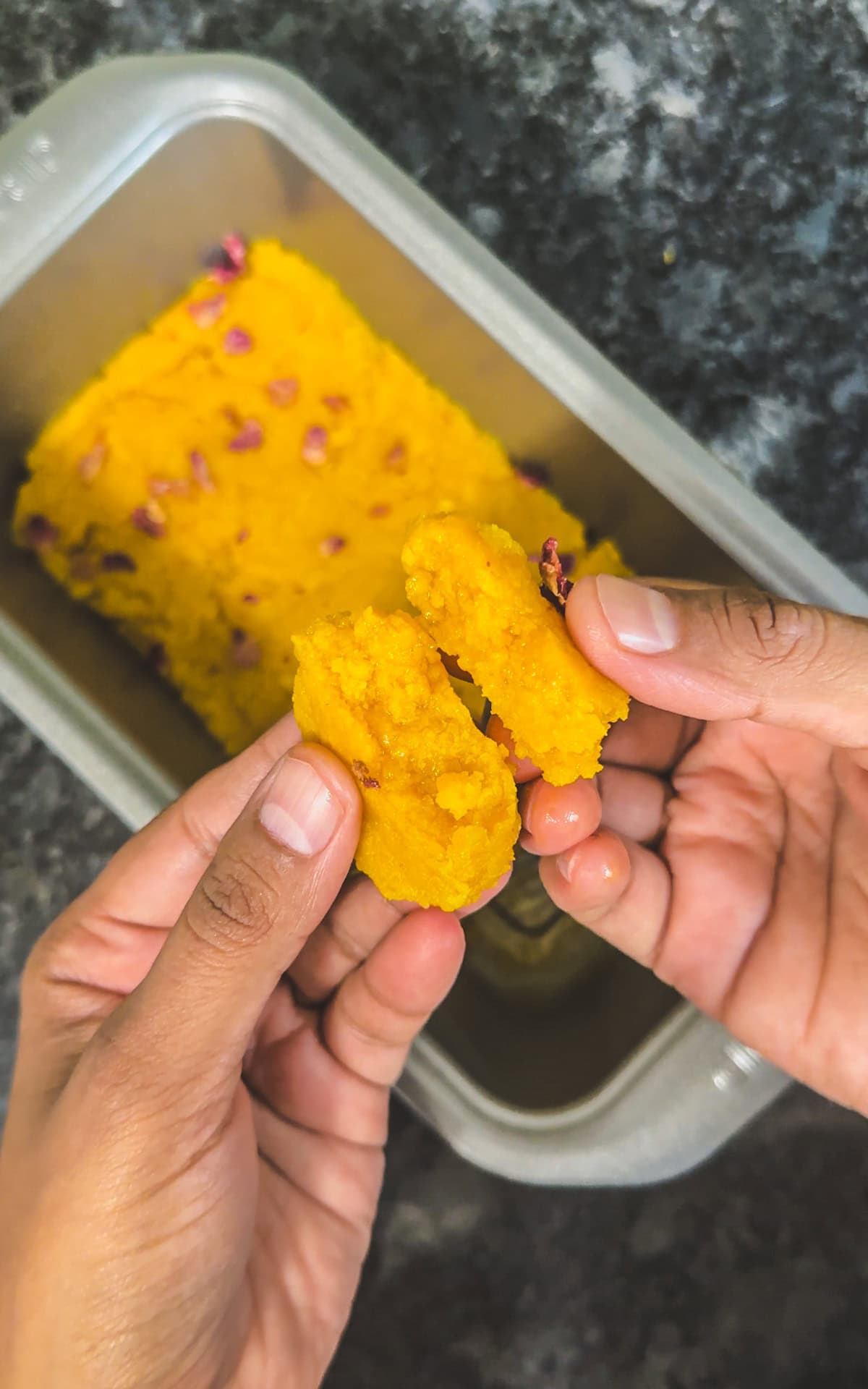 Showing inside texture of mango burfi by breaking the piece in half.