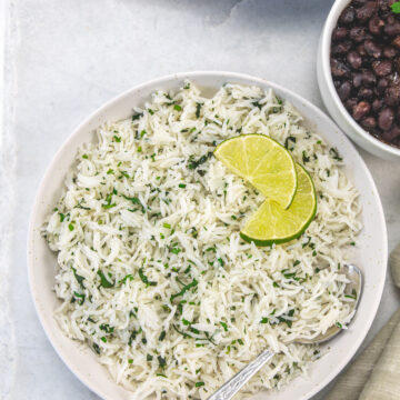 Chipotle cilantro lime rice in a bowl garnished with lime slices.