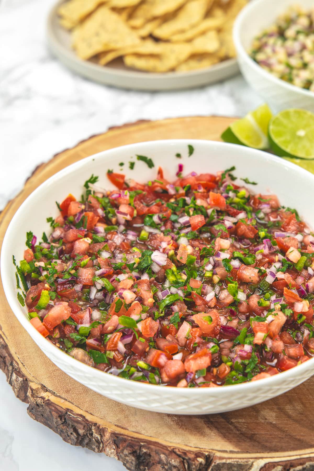 Chipotle fresh tomato salsa in a bowl with chips in the back.