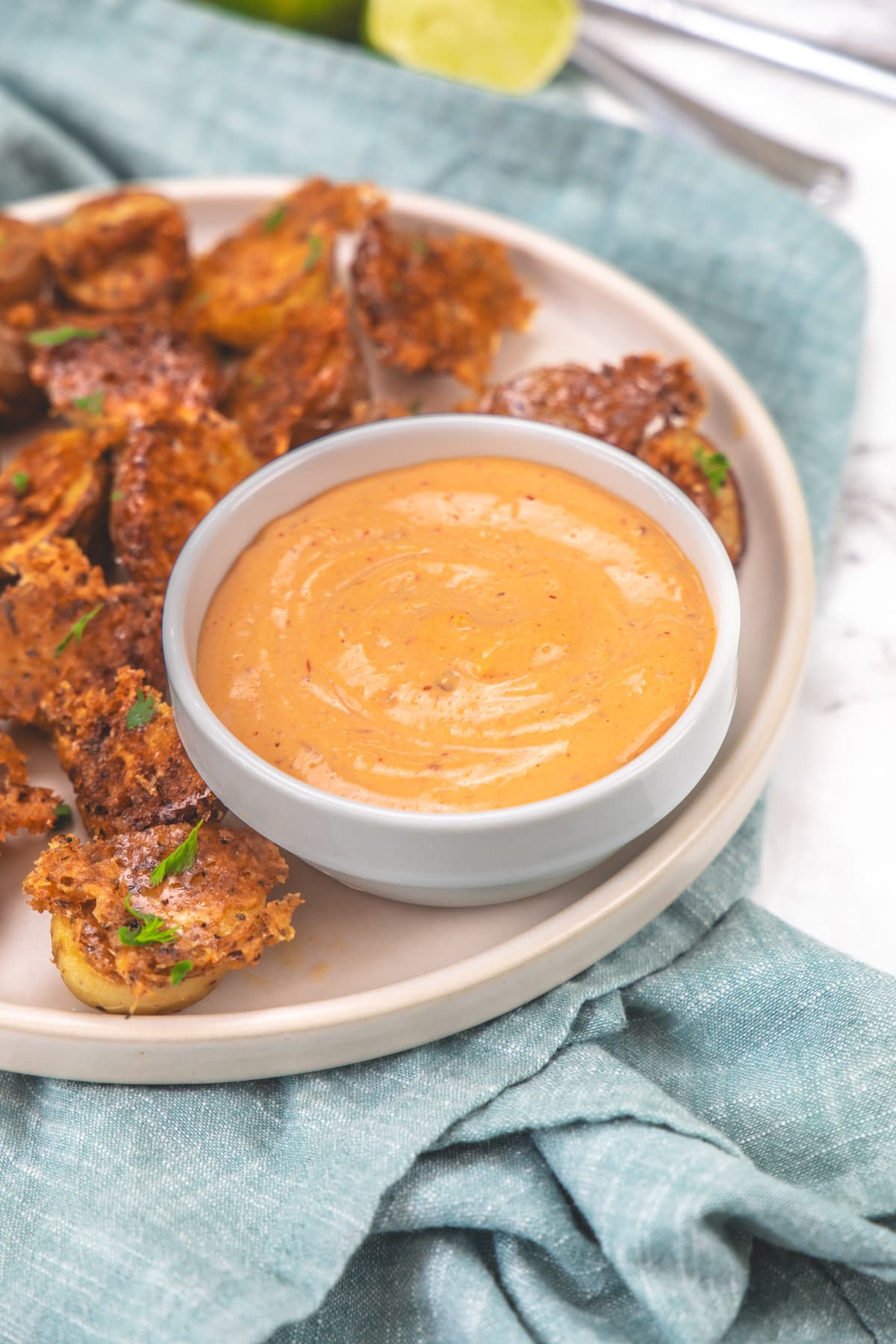 Chipotle mayo in a bowl with potatoes on the side.