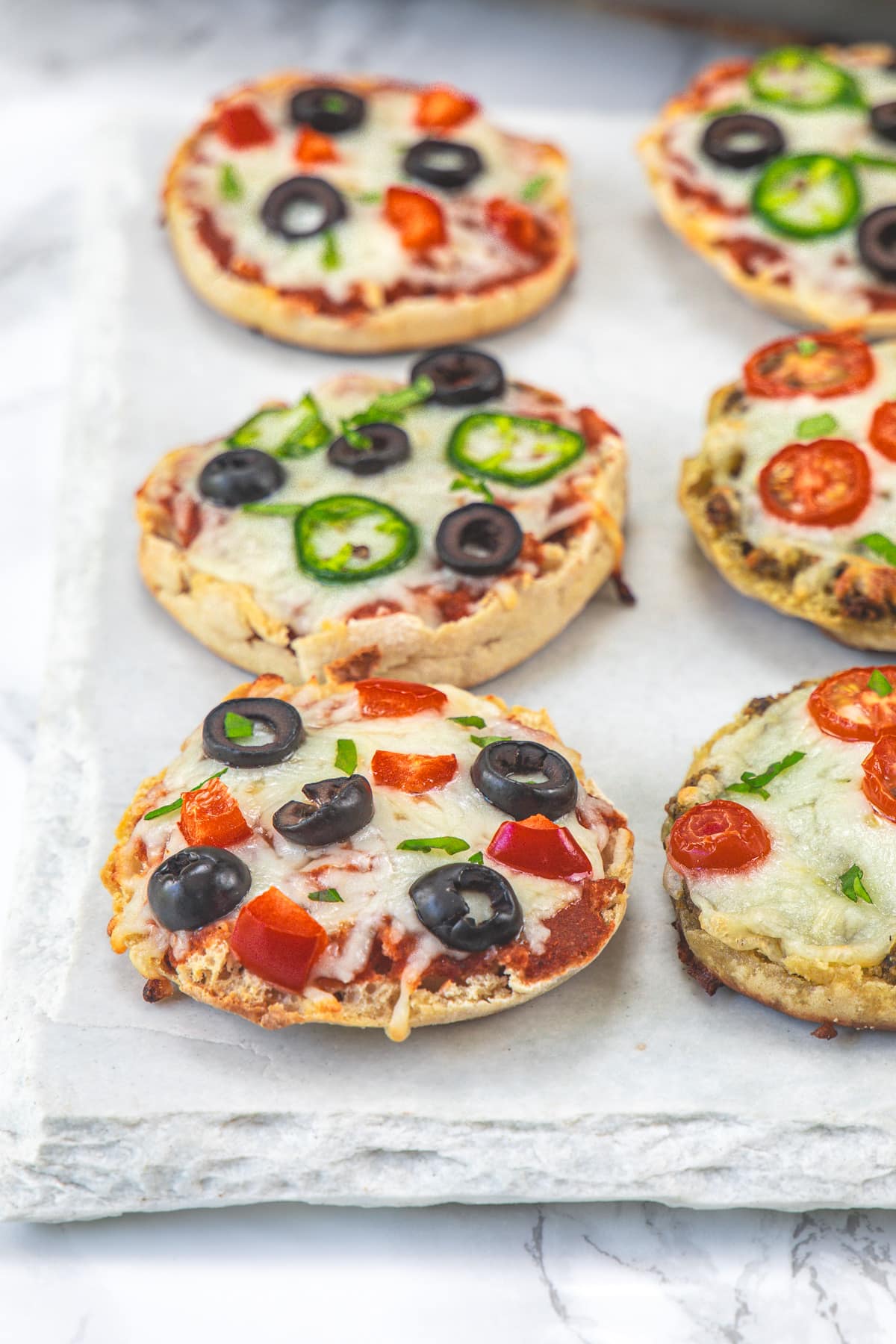 6 English muffin pizza on a marble board.