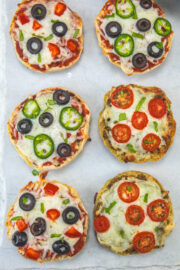 English muffin pizza on a marble surface.