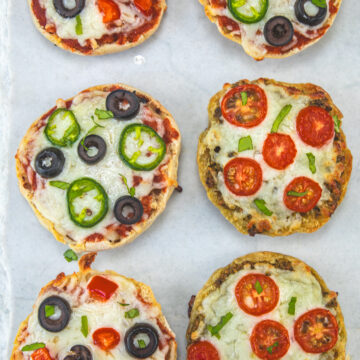 English muffin pizza on a marble surface.