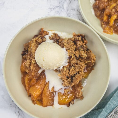 Peach crumble topped with ice cream.