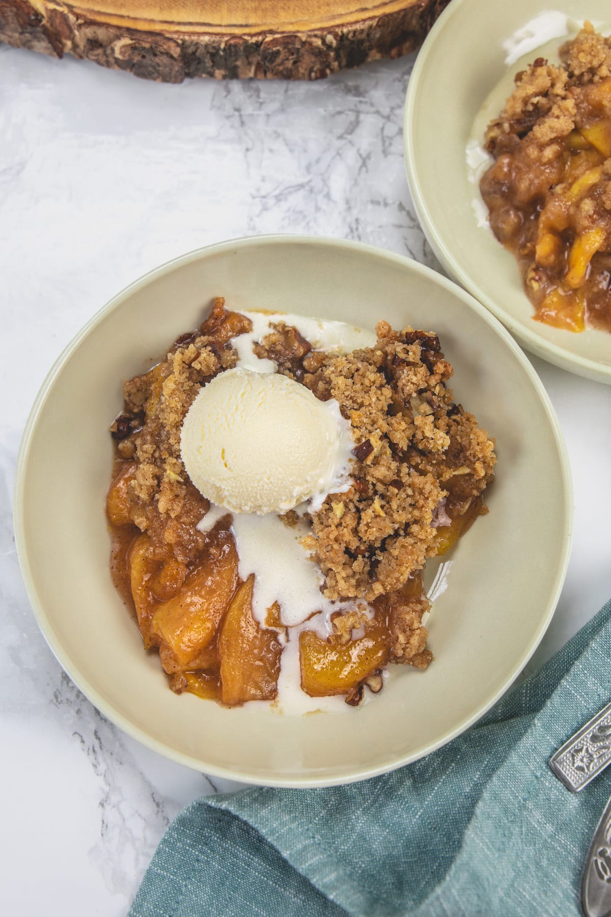 Peach crumble topped with ice cream.