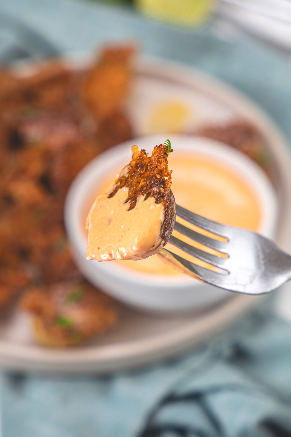 Roasted parmesan potatoes in a fork dipped into chipotle mayo.