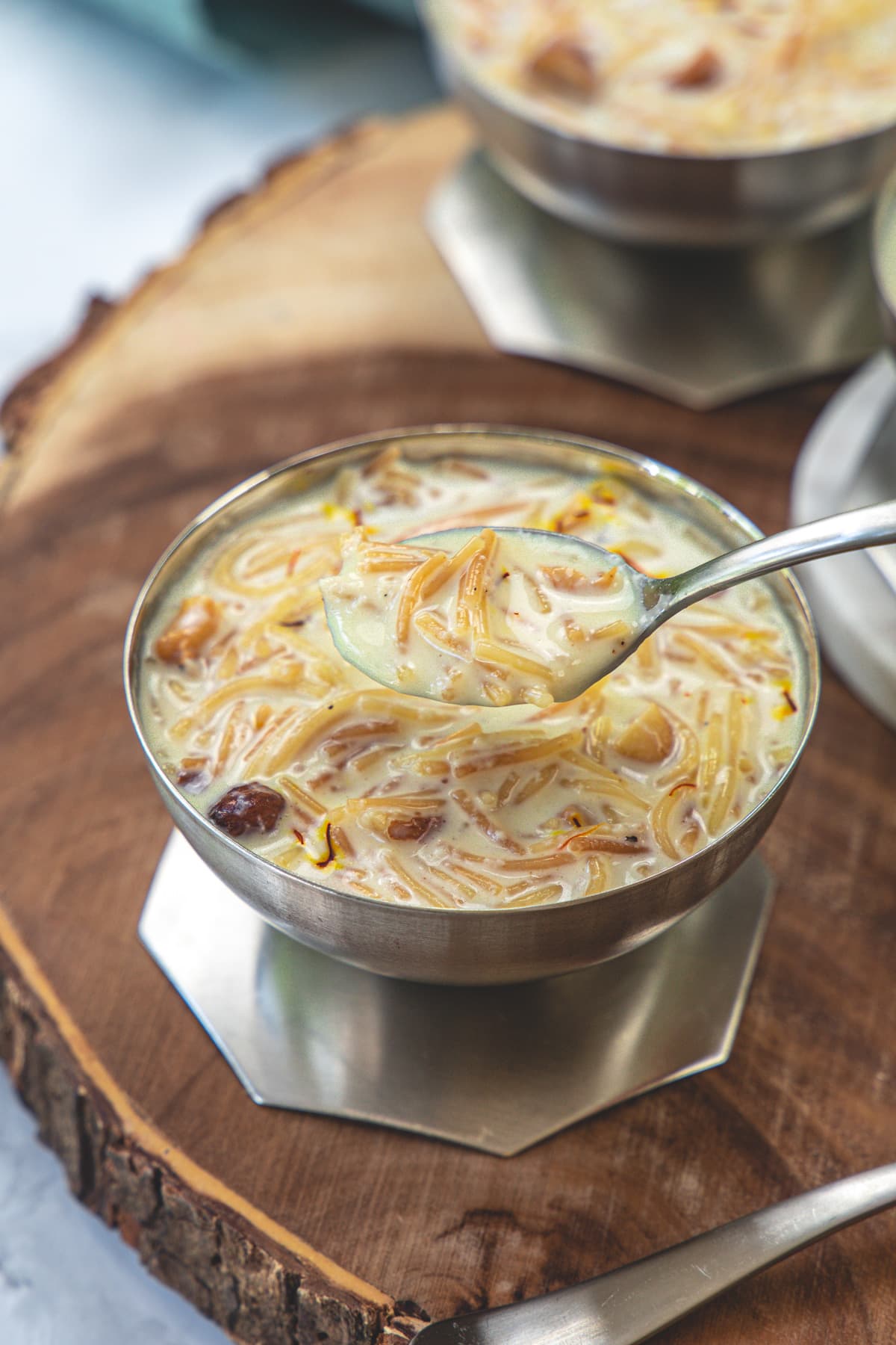 Seviyan kheer in a a bowl and taking a spoonful from it.