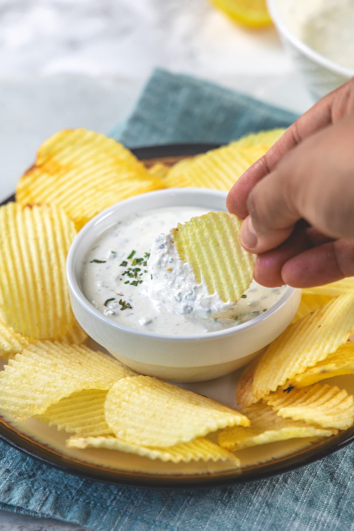 Dipping a potato chip into sour cream dip.