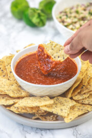 Dipping tortilla chip into tomatillo red chili salsa.