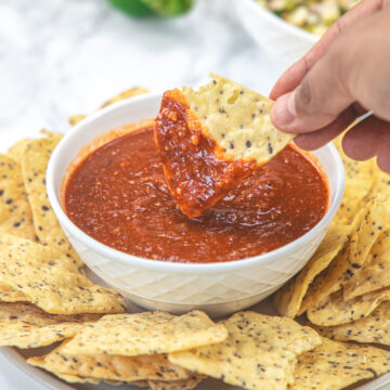 Dipping tortilla chip into tomatillo red chili salsa.