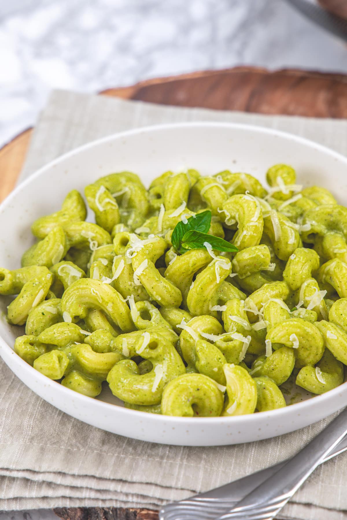 A plate of zucchini pasta garnished with basil leaves.