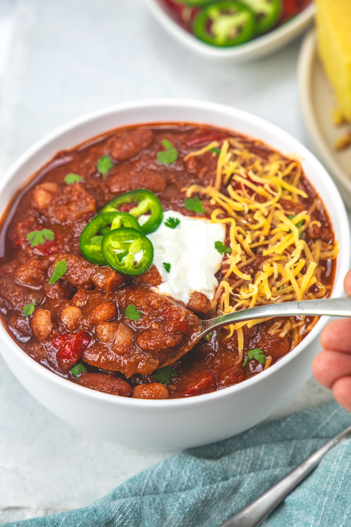 Taking a spoonful of vegetarian chili from the bowl.