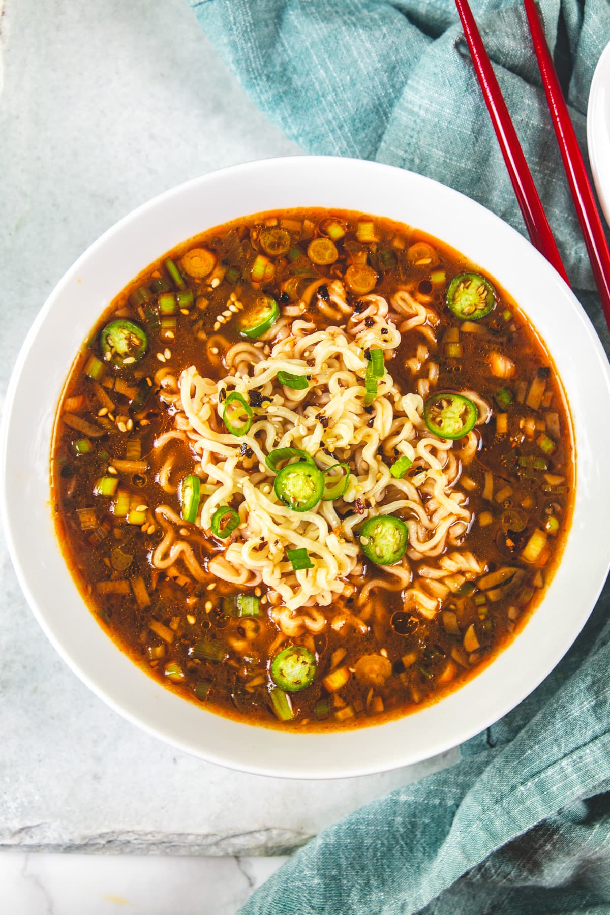 Spicy ramen noodles bowl topped with chili oil, spring onions and green chilies.