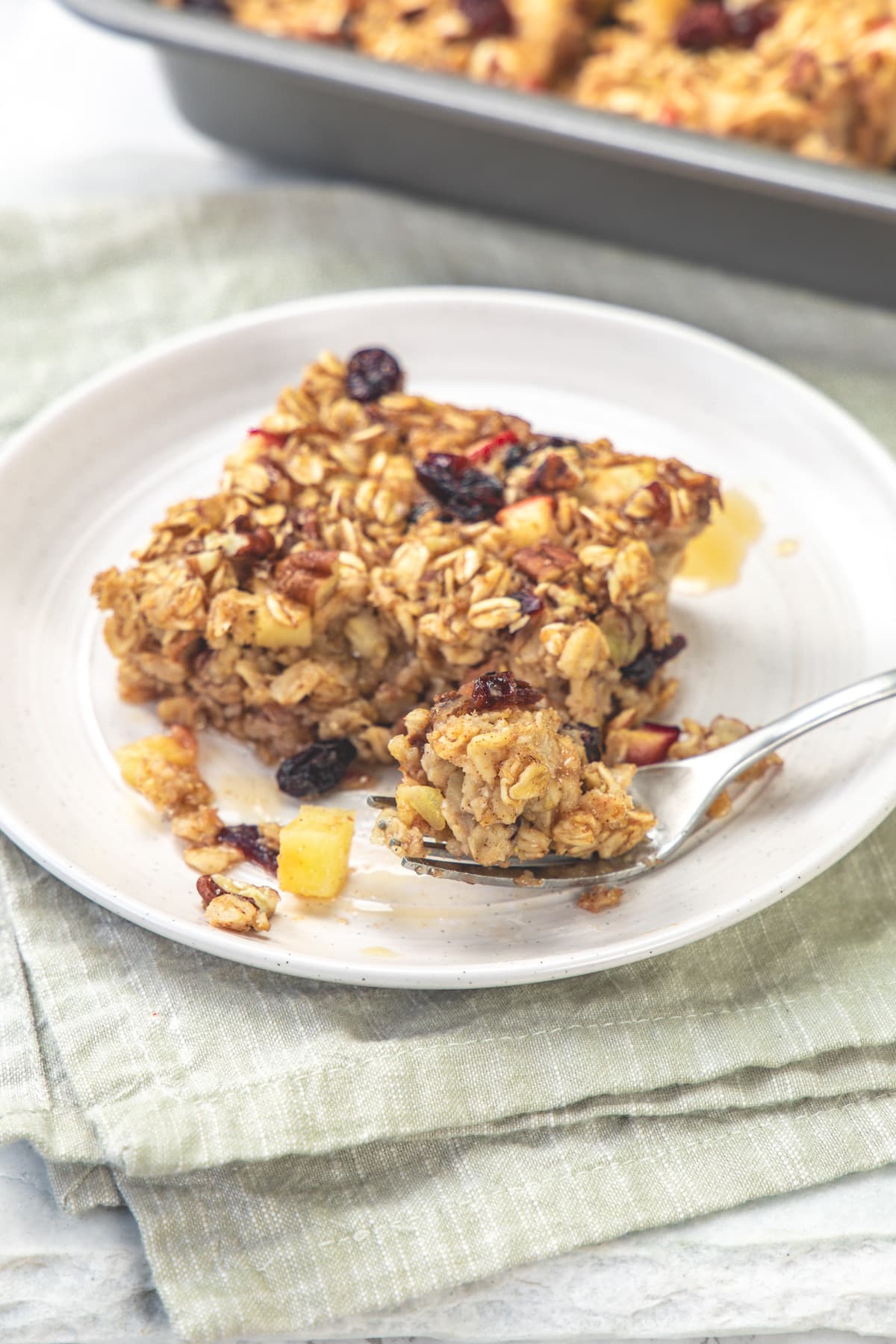 Taking a bite of apple baked oatmeal with a fork.