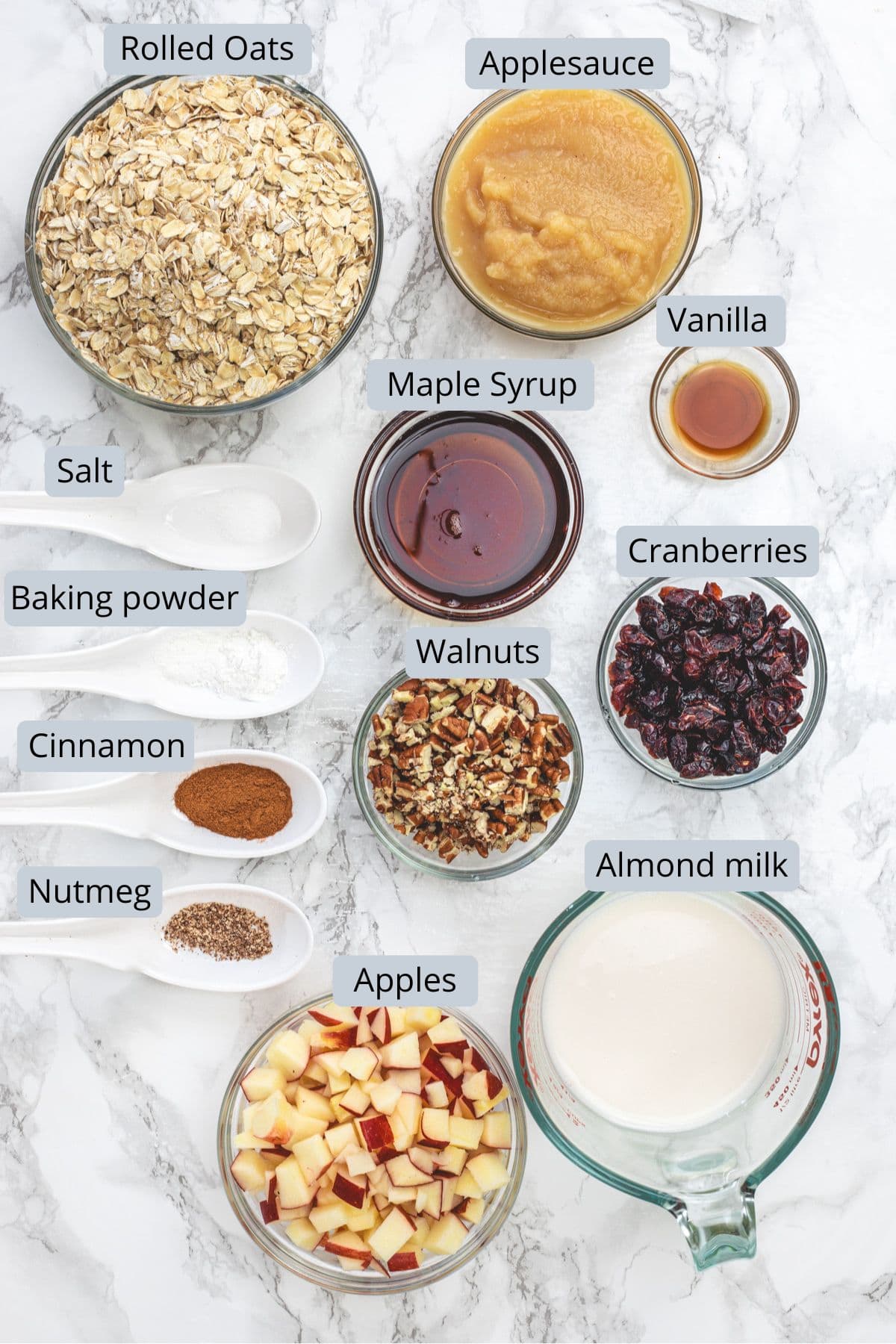 Apple baked oatmeal ingredients in bowls and spoons with labels.