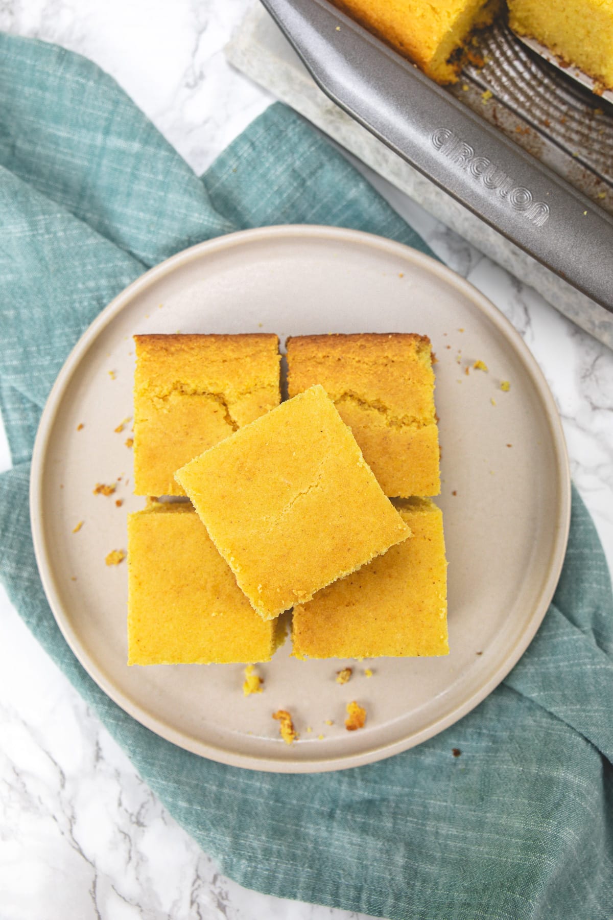 5 pieces of cornbread without eggs on a plate with napkin under the plate.