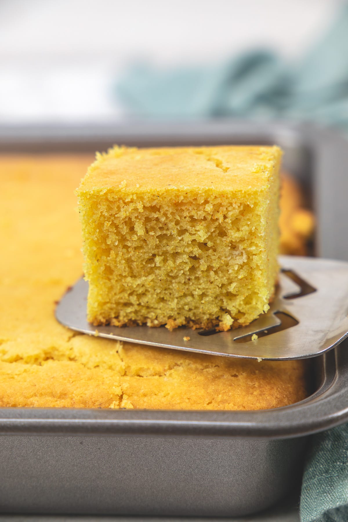 Taking a piece of eggless cornbread using a flat spatula.