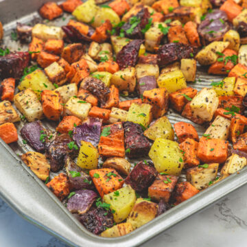 Roasted root vegetables in a baking tray.