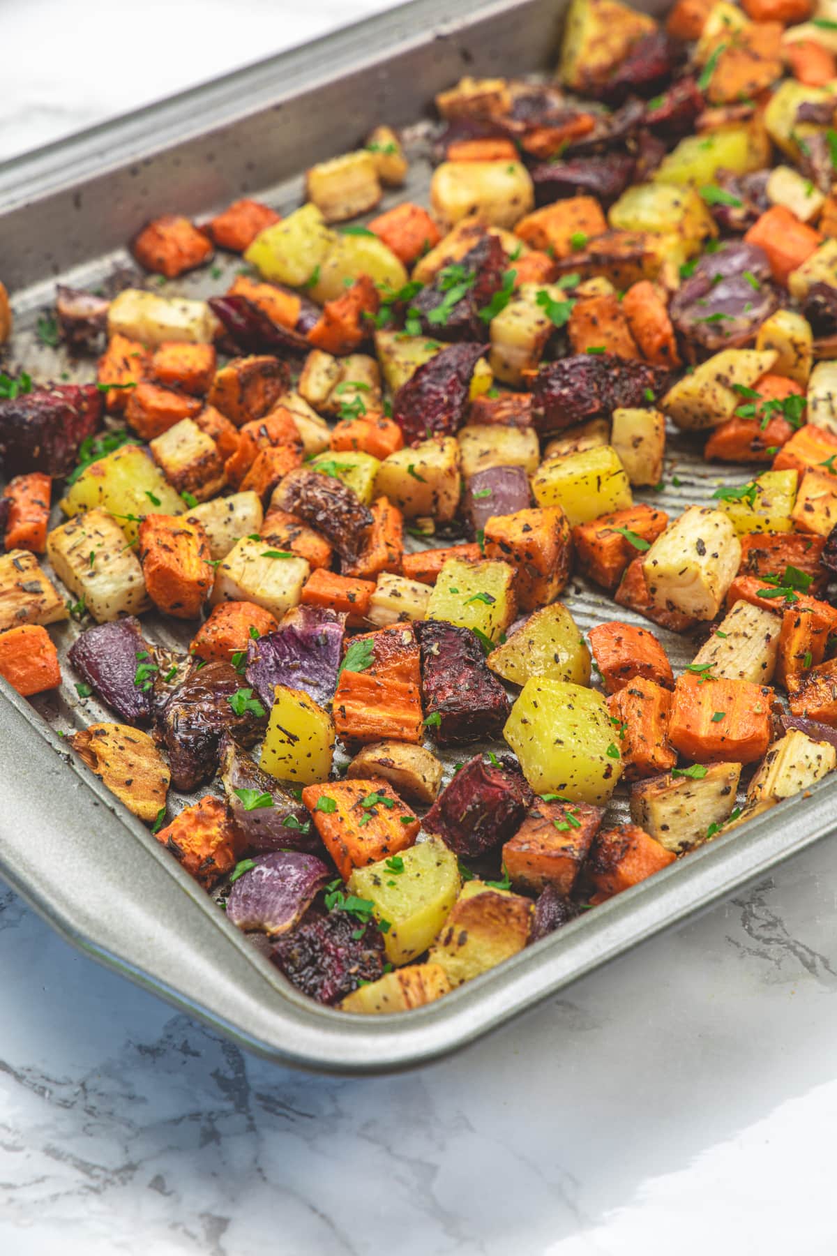Roasted root vegetables in a baking tray.