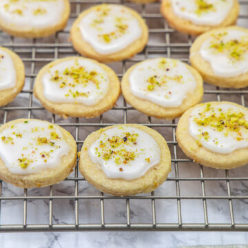 Lemon Shortbread Cookies garnished with pistachios on a cooling rack