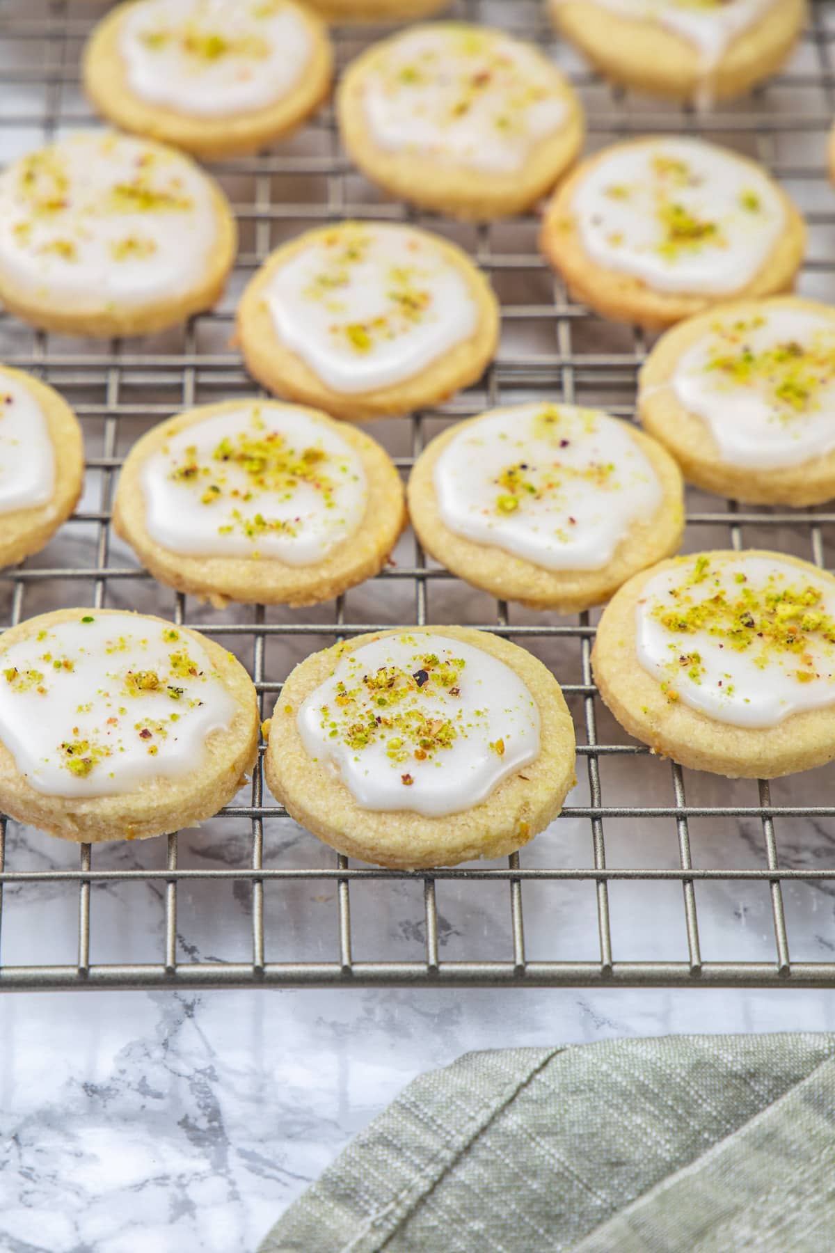 Lemon Shortbread Cookies garnished with pistachios on a cooling rack
