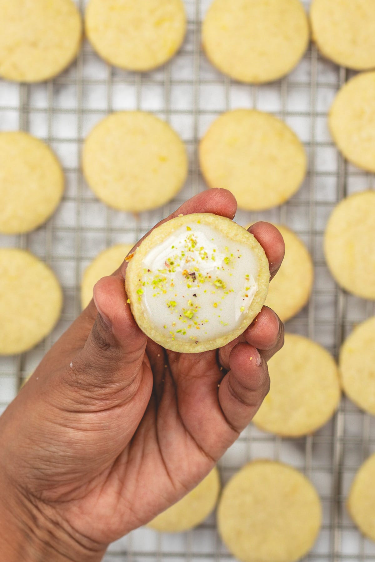 Taking one lemon Shortbread Cookies in a hand.