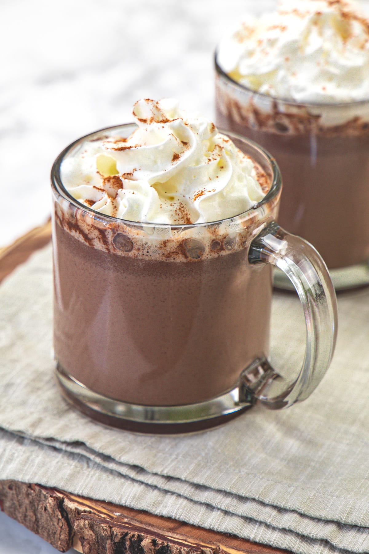 2 glasses of Mexican mocha topped with whipped cream.