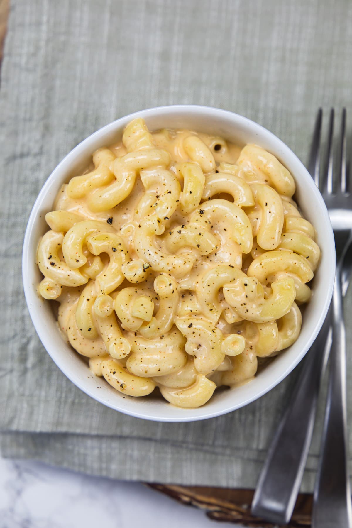 Healthy cottage cheese mac and cheese served in a white bowl with 2 forks.