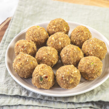 Gond ke laddu in a plate with napkin and wooden board under the plate.