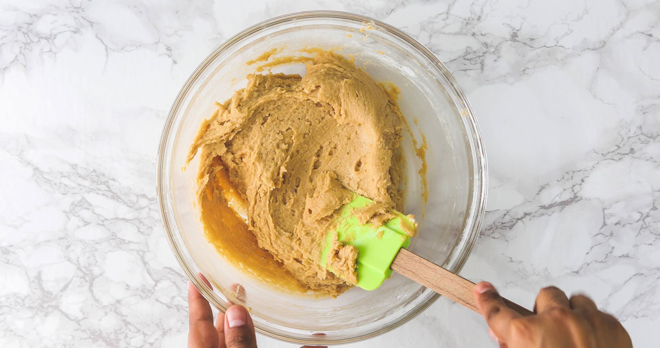 Folding flour mixture using spatula.