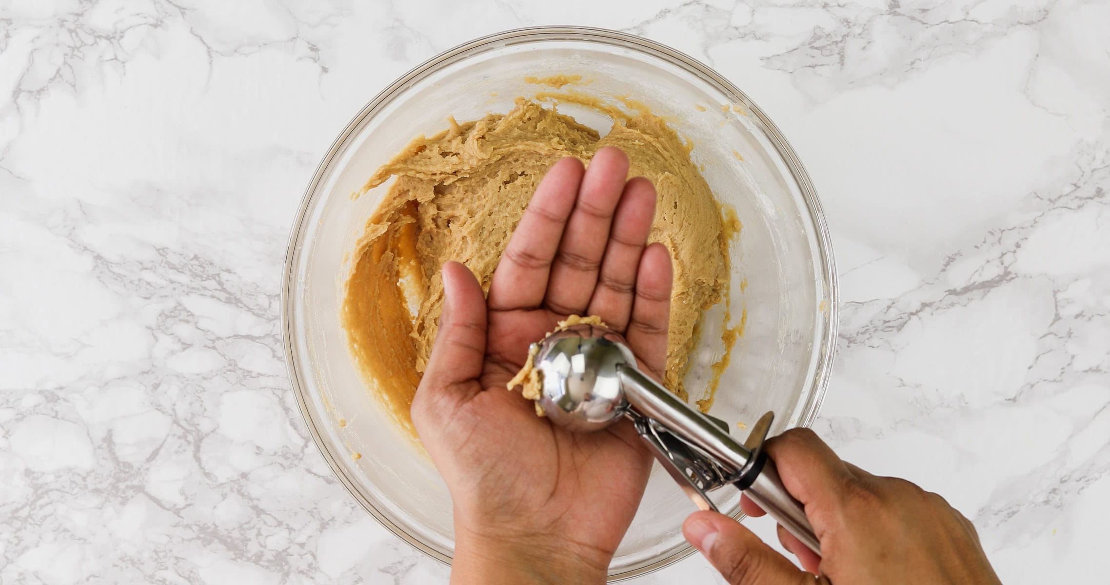 Scooping a dough to make a ball.