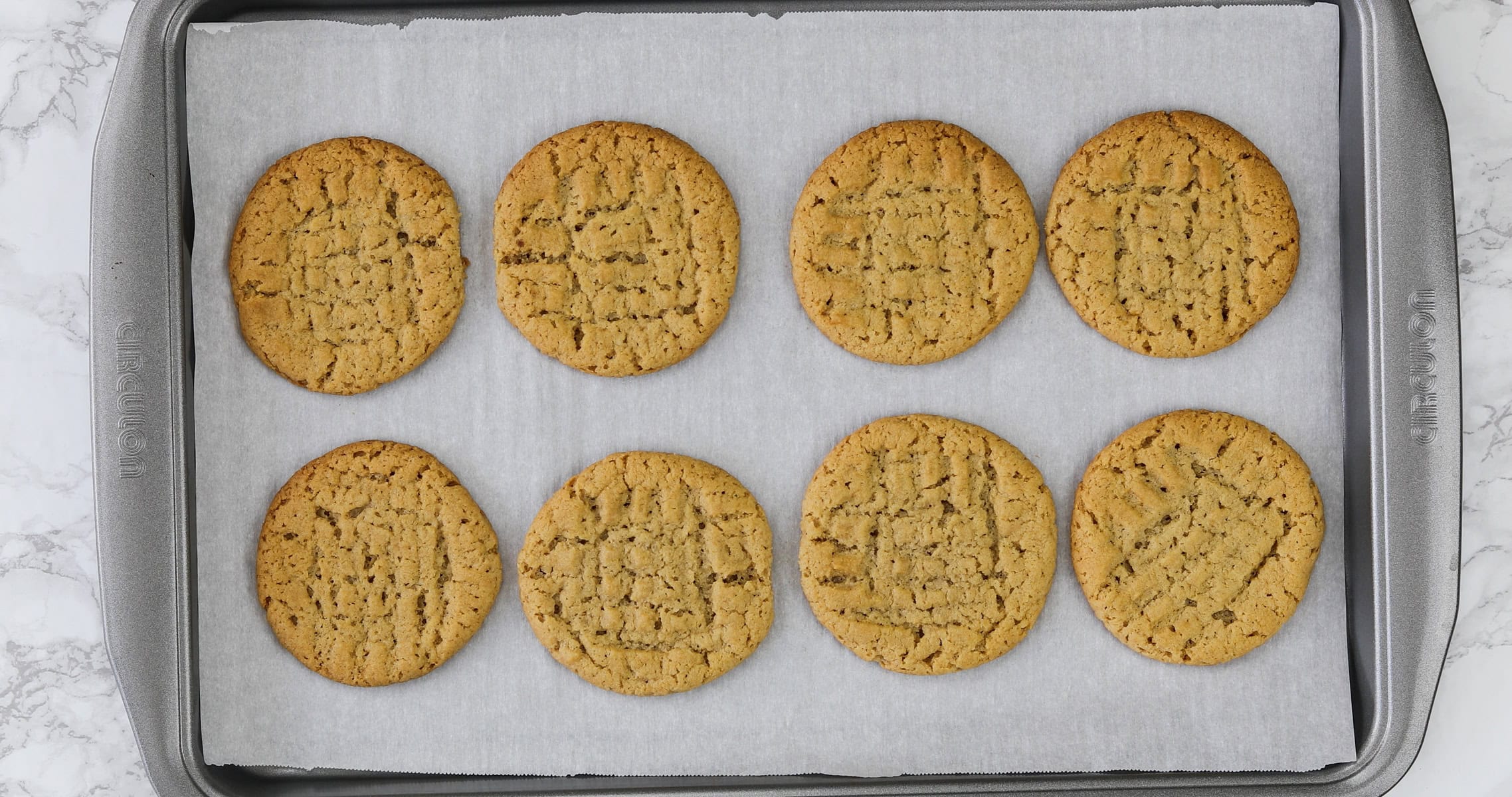 Baked eggless peanut butter cookies in a pan.