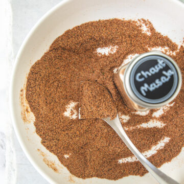 Chaat masala in a plate with labeled spice container.