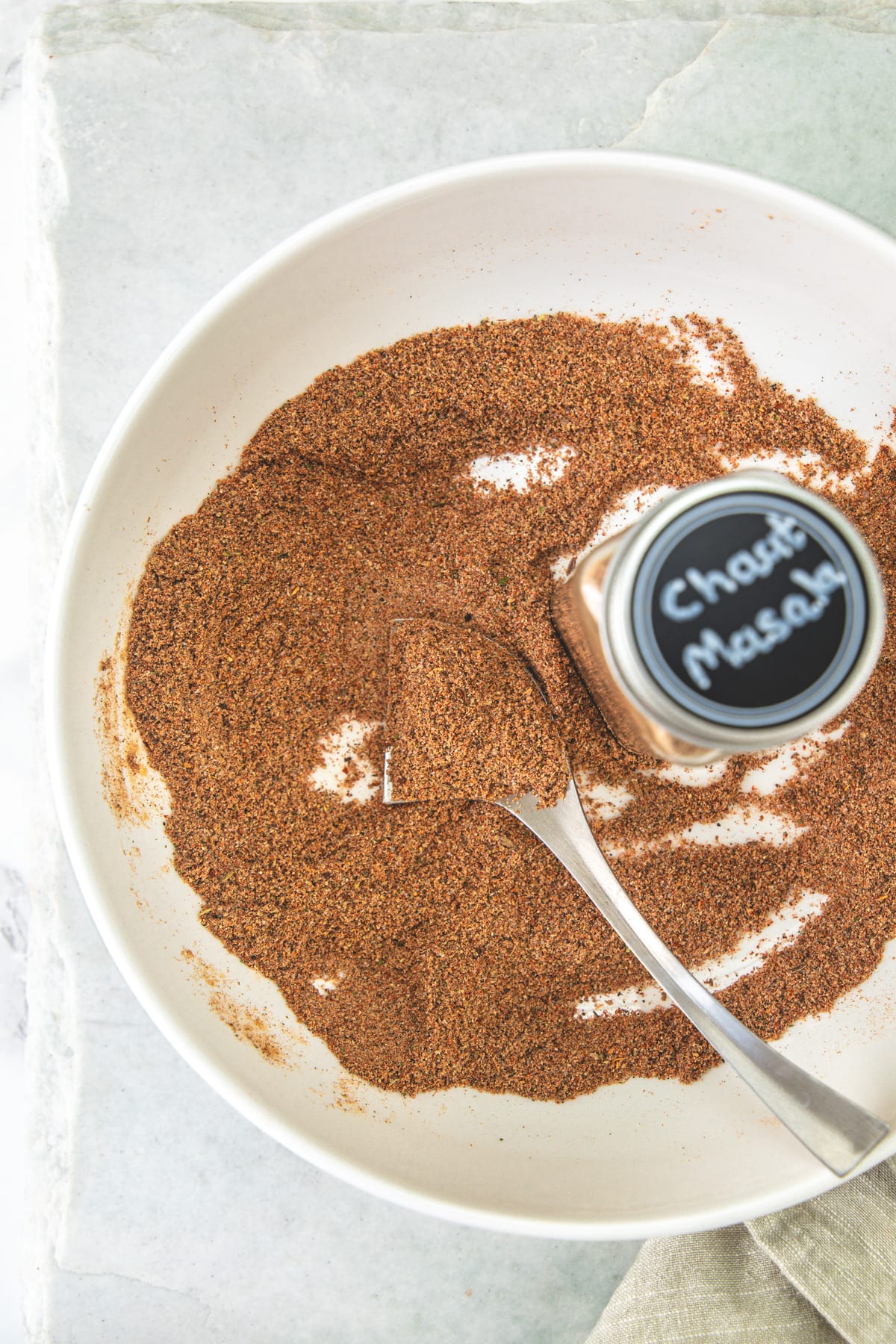 Chaat masala in a plate with labeled spice container.