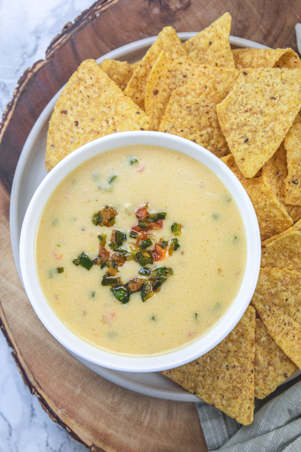 A bowl of copycat chipotle queso blanco with tortilla chips on the side.