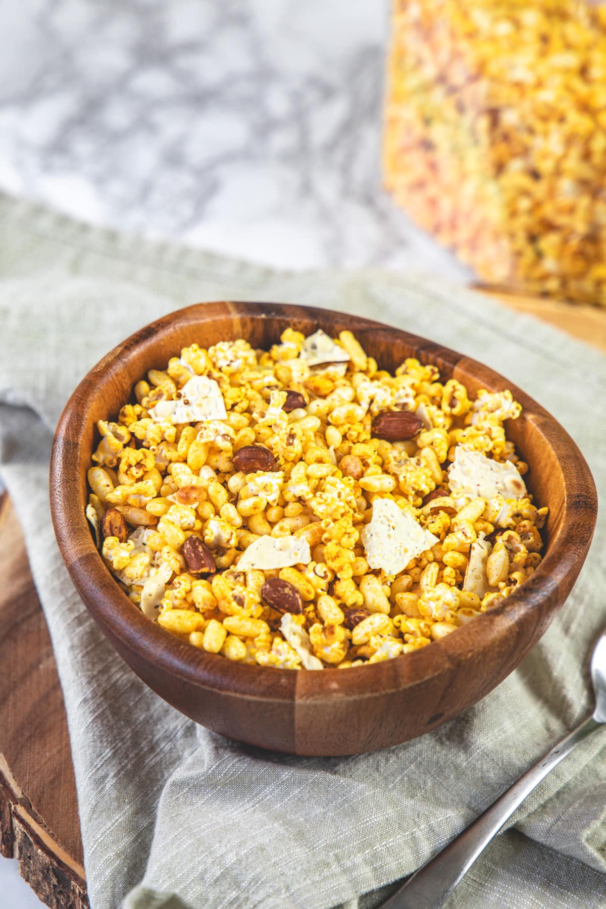 A bowl of jowar dhani chivda with a napkin under it.