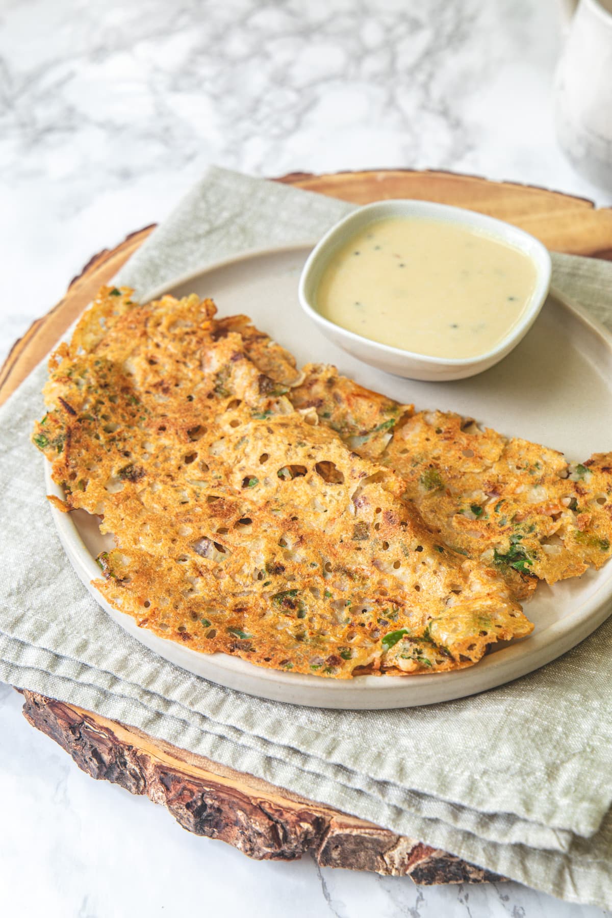 2 jowar dosa served in a plate with coconut chutney.